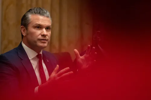 وزير الدفاع الأمريكي بيت هيغسيث يتحدث أثناء اجتماع، مشيرًا بيديه. الصورة توضح أهمية المعلومات العسكرية الحساسة.