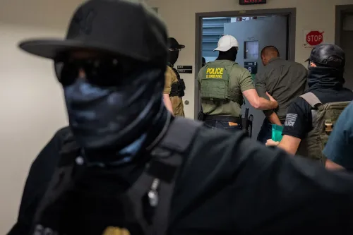 صورة لرجال يرتدون زي الشرطة أثناء اعتقال شخص، مع التركيز على تكتيكات إنفاذ قوانين الهجرة في الولايات المتحدة.