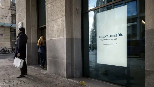 واجهة بنك كريدي سويس تظهر شعار البنك، مع شخصين يدخلان ويخرجان من المبنى، تعبيرًا عن التحديات القانونية والمالية التي يواجهها البنك.