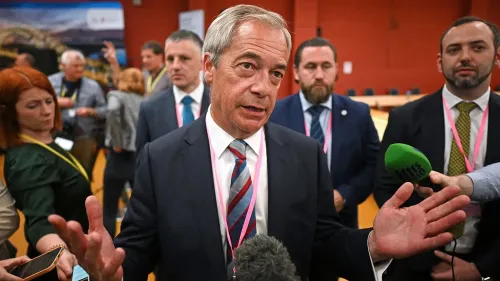 نايجل فاراج يتحدث في مؤتمر صحفي بعد فوز حزبه "الإصلاح البريطاني" بمقعد في البرلمان، محاطًا بمؤيدين وصحفيين.