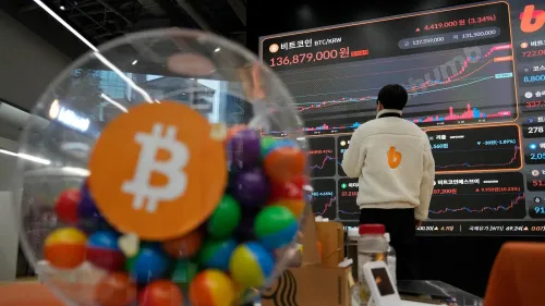 شخص يقف أمام شاشة تعرض بيانات العملات الرقمية، مع وجود وعاء ملون يحمل شعار البيتكوين في المقدمة، مما يعكس اهتمام السوق بالعملات المشفرة.