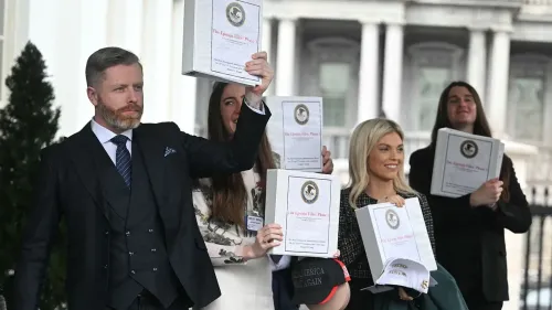 مجموعة من الأشخاص يحملون ملفات تتعلق بقضية جيفري إبشتاين أمام البيت الأبيض، مع التركيز على أهمية الشفافية في التحقيقات.