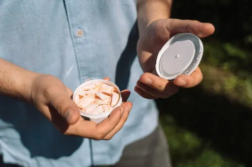 أكياس نيكوتين في يد شخص، تظهر العبوة البيضاء مع محتوياتها، في سياق دعوة إدارة الغذاء والدواء الأمريكية لتغليف مقاوم للأطفال.