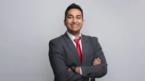 الدكتور فيناي براساد، أخصائي أمراض الدم والأورام، مبتسم ويرتدي بدلة رسمية، مع خلفية بسيطة، بعد تعيينه لقيادة مركز تقييم وأبحاث البيولوجيا في إدارة الغذاء والدواء.