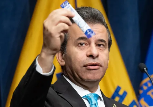 مسؤول صحي يعرض منتج يحتوي على 7-هيدروكسي ميتراجينين، أثناء مؤتمر صحفي حول المخاطر الصحية المرتبطة بالقرطوم.