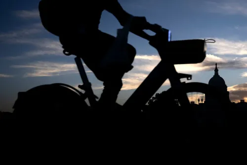 راكب دراجة يظهر في الخلفية مع سماء مضيئة وسطح مبنى حكومي، مما يعكس تأثير الإغلاق الفيدرالي على الموظفين.