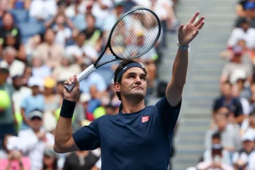 روجر فيدرر يرفع مضرب التنس في ملعب آرثر آش خلال عودته الرمزية لبطولة US Open بعد غياب طويل.