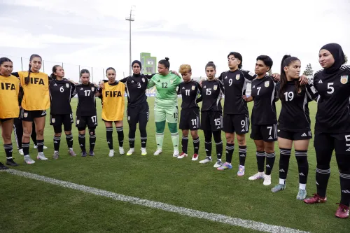 تجمع لاعبات المنتخب النسائي الأفغاني في المنفى، يرتدين زيًا رياضيًا أسود، استعدادًا للمنافسة تحت شعار FIFA بعد قرار تاريخي يتيح لهن تمثيل بلادهن رسميًا.