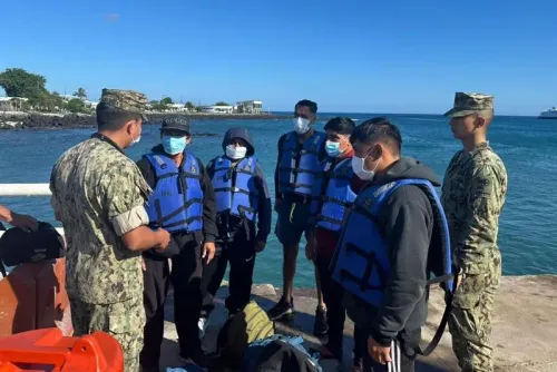 ستة رجال يرتدون سترات النجاة يتحدثون مع ضابط بحري في ميناء جزر غالاباغوس بعد إنقاذهم من البحر.