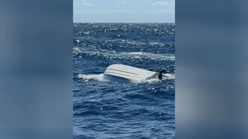 قارب مقلوب في مياه المحيط، مع شخص يسبح بالقرب منه، في سياق حادث غرق قبالة ساحل فلوريدا.