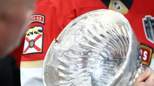 كأس ستانلي يظهر مع صدع واضح في الجزء العلوي، بينما يرتدي أحد لاعبي فلوريدا بانثرز قميص الفريق خلال احتفالات الفوز.