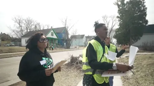 متطوعون يرتدون سترات صفراء، يقومون بجولات طرق الأبواب في حي، ويستعدون لتعزيز المشاركة الانتخابية في ويسكونسن.