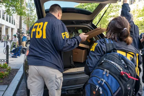 عملاء من مكتب التحقيقات الفيدرالي يجمعون مستندات من سيارة أثناء تفتيش منزل جون بولتون في ماريلاند، في إطار تحقيق حول سجلات سرية.