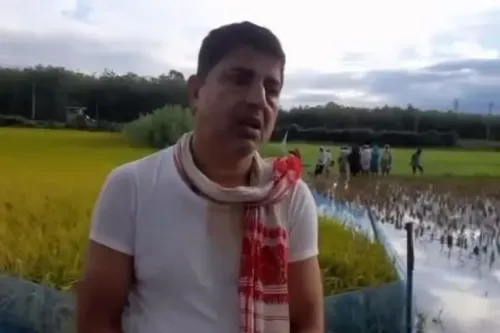 علي، ميكانيكي دراجات هوائية في آسام، يتحدث عن تجربته الصعبة بعد احتجازه وترحيله إلى بنغلاديش، بينما يظهر خلفه حقول الأرز.