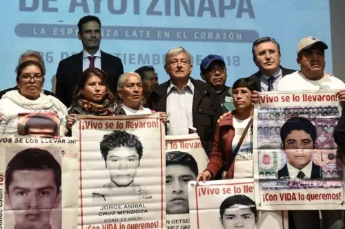 مجموعة من الأشخاص يحملون لافتات تحمل صورًا لأشخاص مفقودين، في فعالية تذكارية تتعلق بقضية اختفاء 43 طالبًا في المكسيك.