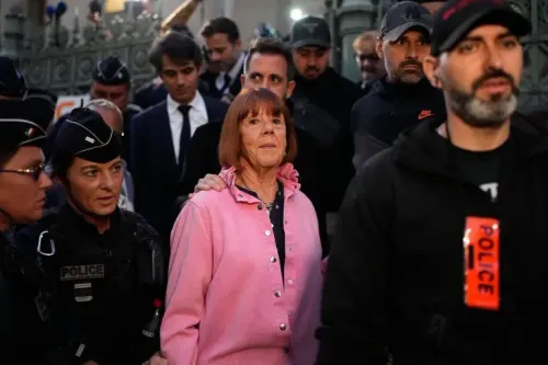 امرأة مسنّة ترتدي سترة وردية، محاطة برجال شرطة ومشاهدين، تظهر بعد الحكم في قضية اعتداء جنسي بارزة في فرنسا.