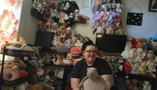 امرأة تجلس أمام مجموعة كبيرة من الدمى المحشوة، تشمل حيوانات متنوعة وأشكال مختلفة، تعكس شغف البالغين باللعب.