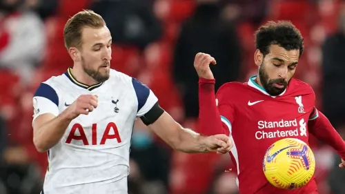 مواجهة بين هاري كين ومحمد صلاح خلال مباراة كرة قدم، تعكس تأثير نجوم الدوري الإنجليزي على سوق انتقالات دوري روشن السعودي.