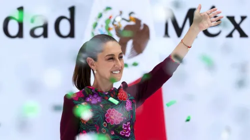 كلوديا شينباوم، أول رئيسة للمكسيك، تلوح بيدها وسط احتفالات، مع خلفية العلم المكسيكي، تعبيرًا عن دعم شعبي كبير.
