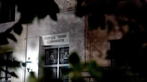 مبنى لجنة التجارة الفيدرالية الأمريكية مع إضاءة خافتة، يظهر اسم اللجنة بوضوح، محاط بأوراق الشجر، في سياق قضايا أمازون.