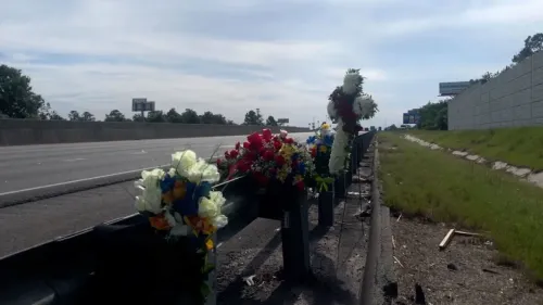 تظهر الصورة زهورًا اصطناعية ملونة مثبتة على سياج على جانب الطريق السريع، تكريمًا لذكرى النائب براندون سايكس الذي قُتل في حادث إطلاق نار.