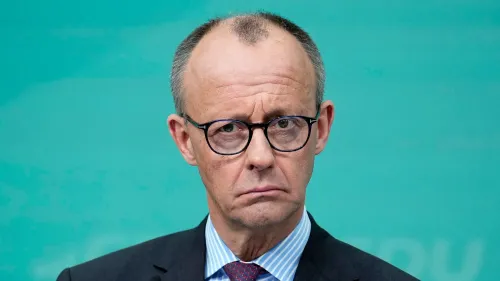 فريدريش ميرتس، زعيم حزب الاتحاد الديمقراطي المسيحي، يظهر بملامح جدية، خلفه خلفية زرقاء، في سياق المفاوضات الائتلافية في ألمانيا.