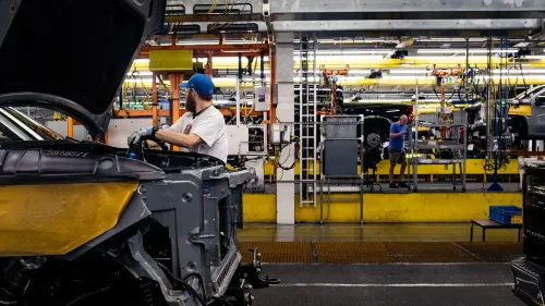 عمال في مصنع جنرال موتورز يقومون بتجميع السيارات، وسط معدات وآلات حديثة، في إطار الاستعداد لعام 2024 وتوقعات الربح.