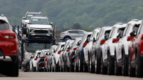 سيارات جديدة من جنرال موتورز مركونة على شاحنة، تعكس تأثير الرسوم الجمركية على صناعة السيارات في الولايات المتحدة.