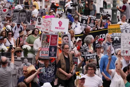 مظاهرة حاشدة ضد سياسات ترامب، حيث يحمل المتظاهرون لافتات تطالب بإنهاء الترحيل الجماعي وحقوق المهاجرين، في مشهد يعكس الغضب الشعبي.