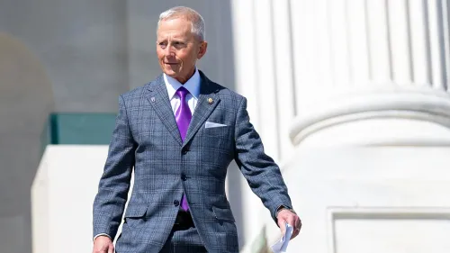 النائب جيف فان درو يرتدي بدلة رمادية ويغادر مبنى الكونغرس، مع التركيز على قضايا برنامج Medicaid وأولويات الحزب الجمهوري.