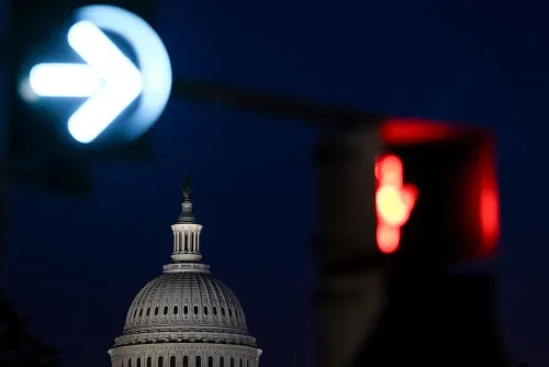 صورة لواجهة مبنى الكابيتول الأمريكي مع إشارة مرور حمراء وزرقاء، تعكس حالة عدم اليقين الاقتصادي بسبب الإغلاق الحكومي وتأثيره على البيانات المالية.