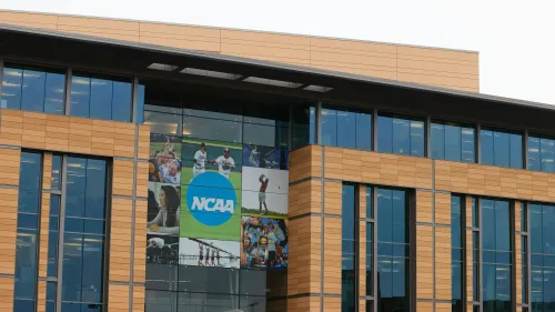 مبنى الرابطة الوطنية لرياضة الجامعات (NCAA) مع لافتة كبيرة تحمل شعار الرابطة، يرمز إلى التغييرات الجديدة في قوانين الرياضة الجامعية.
