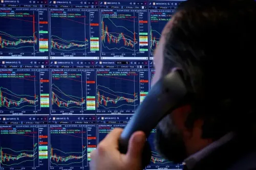 شخص يتحدث على الهاتف أمام شاشات تعرض بيانات سوق الأسهم، مع التركيز على تقلبات مؤشر ستاندرد آند بورز 500.