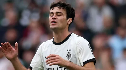 لاعب الوسط الهجومي جيوفاني رينا في مباراة مع بوروسيا مونشنغلادباخ يعبر عن إحباطه وسط أجواء المباراة في الدوري الألماني.
