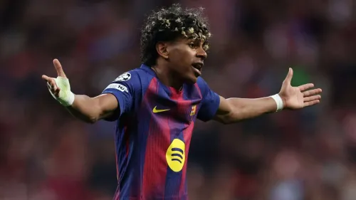 لاعب برشلونة لامين يمال يرفع ذراعيه بتعبير حائر خلال مباراة، مع التركيز على مستقبله الكروي بعد تحقيق ألقاب كبيرة في سن مبكرة.