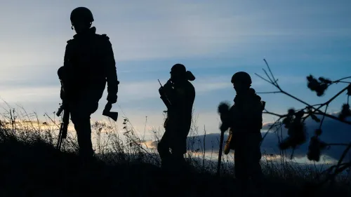 جنود أوكرانيون يسيرون في صفوف، silhouetted against غروب الشمس، مما يعكس تأثير الحرب على الحياة المدنية والعنف الأسري.