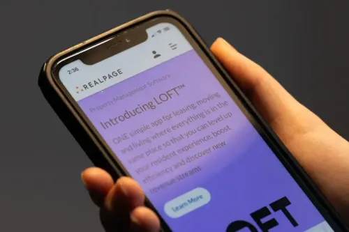 تظهر الصورة يدًا تمسك بهاتف ذكي يعرض تطبيق LOFT لإدارة الممتلكات، الذي يسهل عملية التأجير والإقامة.