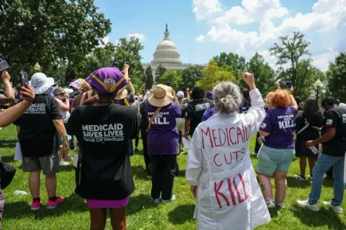 تجمع حشود أمام الكابيتول هيل للاحتجاج على تخفيضات برنامج Medicaid، مع شعارات تدعو للحفاظ على الرعاية الصحية.