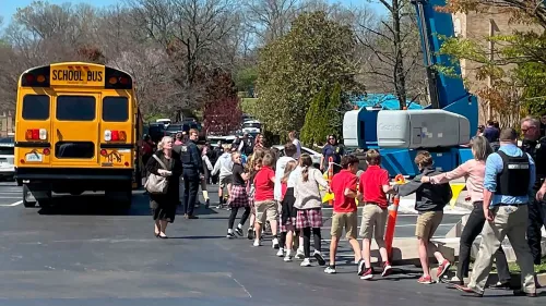 طلاب يتجهون نحو حافلة مدرسية بعد حادث إطلاق نار في مدرسة العهد بناشفيل، مع وجود رجال الشرطة في الموقع.