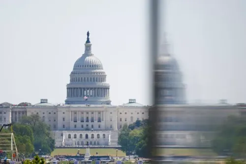 مبنى الكابيتول الأمريكي، مع تفاصيل معمارية بارزة، يظهر في الخلفية، مما يعكس أهمية التشريع الجديد وتأثيره على الاقتصاد الأمريكي.