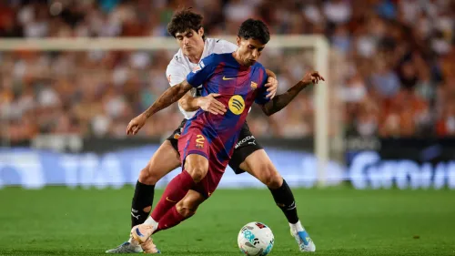 لاعب برشلونة جواو كانسيلو يسيطر على الكرة خلال مباراة حماسية، مع استمرار المفاوضات لإعادته للنادي بشكل دائم.