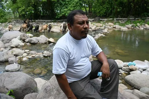 خوان لوبيز، ناشط بيئي في هندوراس، يجلس على صخرة بجانب نهر في منطقة كولون، حيث يقاوم مشروع تعدين يهدد البيئة.
