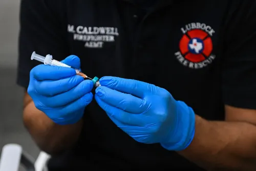 ممارس صحي يرتدي قفازات زرقاء، يمسك بإبرة وعبوة لقاح، في سياق جهود التطعيم ضد الحصبة في الولايات المتحدة.