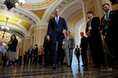 مجموعة من أعضاء مجلس النواب تسير في ممر الكابيتول، مع التركيز على زعيم الأغلبية جون ثون، بعد تصويت لإلغاء بند قانوني مثير للجدل.