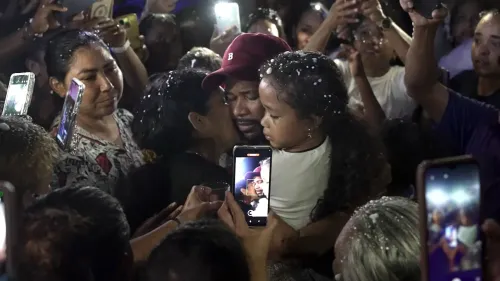 لقاء مؤثر بين المهاجرين الفنزويليين وعائلاتهم بعد الإفراج عنهم، يظهر مشاعر الفرح والارتباط العائلي وسط حشود تحمل الهواتف لتوثيق اللحظة.