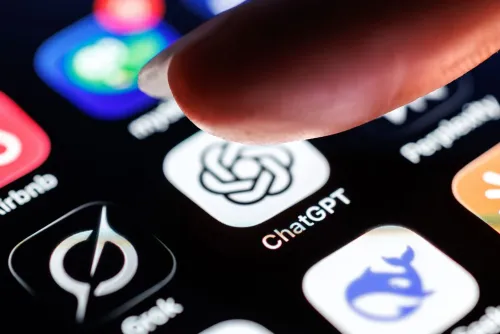 صورة تظهر إصبعًا يضغط على أيقونة تطبيق ChatGPT بين مجموعة من التطبيقات الأخرى على شاشة هاتف ذكي، مما يعكس استخدام الذكاء الاصطناعي في الحياة اليومية.
