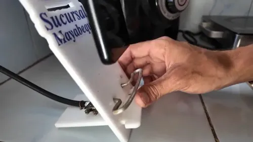 يد شخص يضبط هوائي إنترنت محلي الصنع في كوبا، يعكس ابتكاراً رقمياً لمواجهة انقطاعات الكهرباء والعقوبات الاقتصادية.