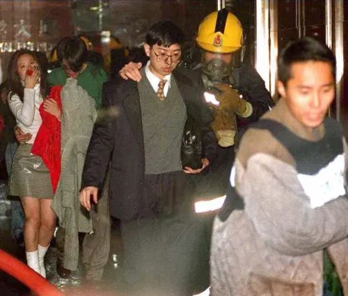 ناجون من حريق مميت في مجمع سكني بهونغ كونغ، حيث تم إنقاذهم بواسطة رجال الإطفاء وسط حالة من الفوضى والذعر.