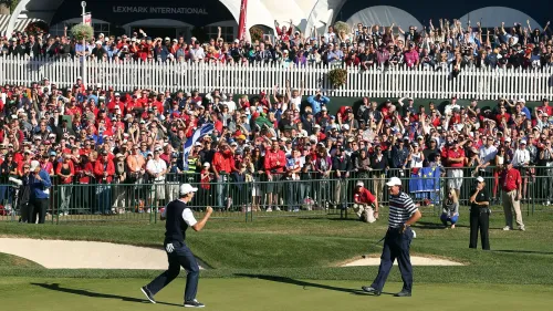 جمهور كبير يشاهد لاعبي جولف يتفاعلان في ملعب، مع وجود مشجعين يرتدون قمصان حمراء وخلفية من السياج الأبيض.