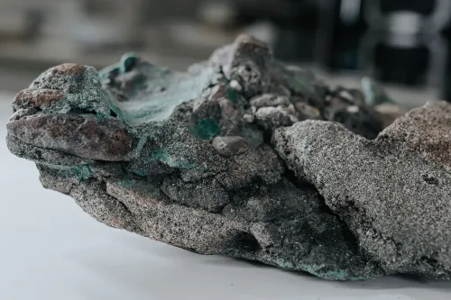 صخرة بلاستيكية مختلطة مع مواد طبيعية، تظهر آثار تآكل وتغيرات كيميائية نتيجة التلوث البلاستيكي.